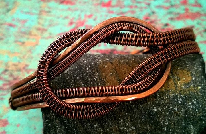 A wire woven knotted cuff featuring peened texture.