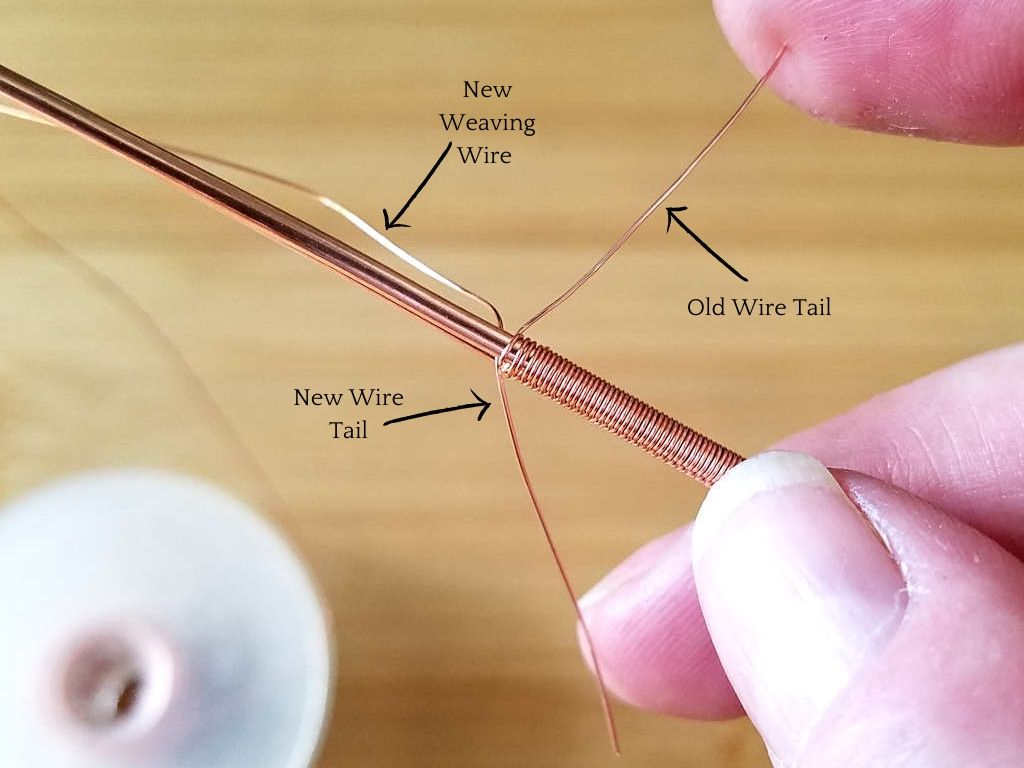 Step 2 - slide the tail of the new weaving wire next to the tail of the old weaving wire. You should have one wire tail coming out on each side of the weave, and your new weaving wire should be on the same side of the weave as the tail of the old weaving wire, as shown in this image. 
