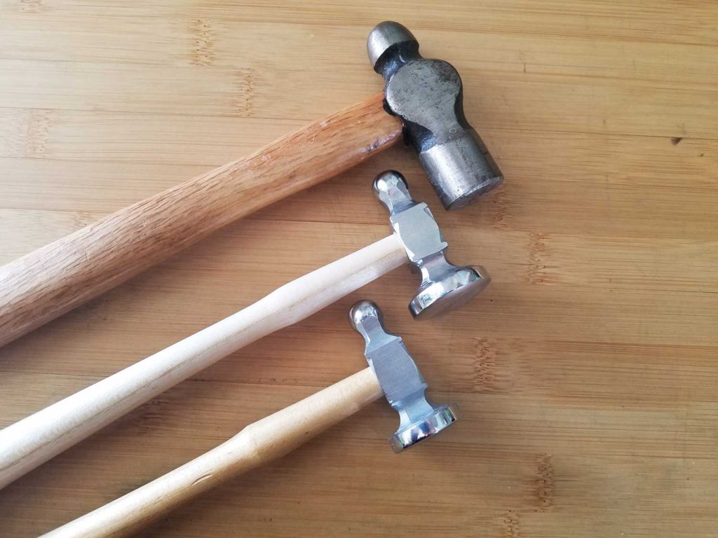 A mechanic's ball peen hammer and two jeweler's chasing hammers, pictured side by side for comparison