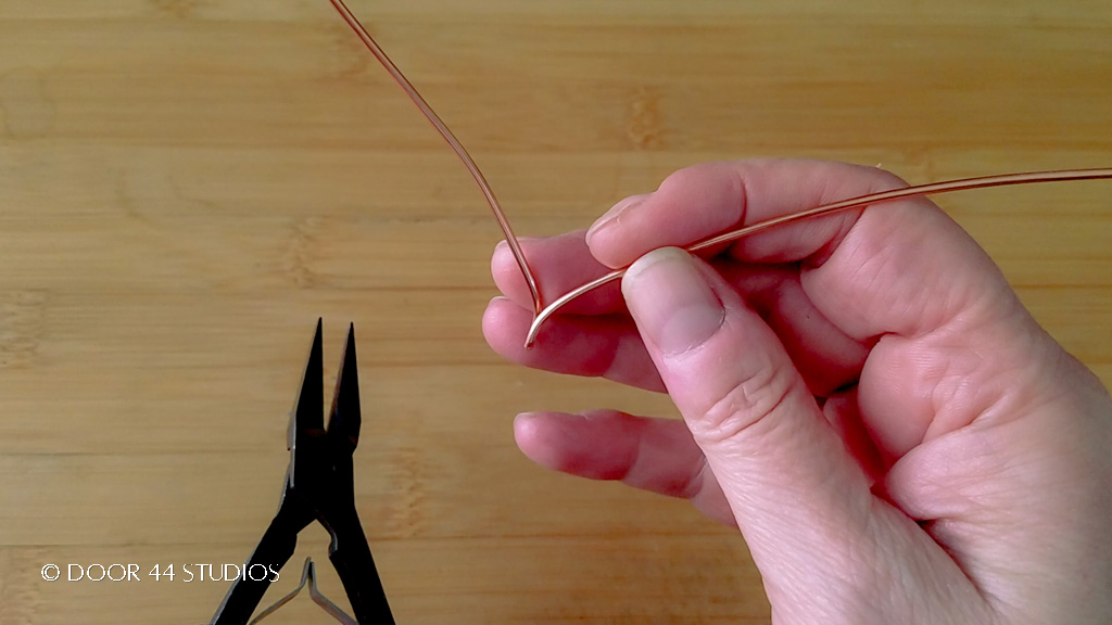 Step 2: Gently spread the two ends of the wire apart, as shown. 