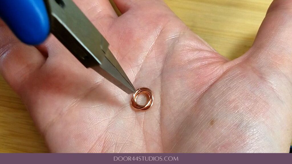 Settling the rings into a nested mobius flower with the tips of pliers